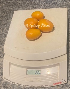cumquat fruit on a kitchen scale