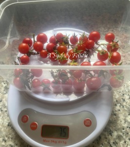 cherry tomatoes in a plastic container on a kitchen scale